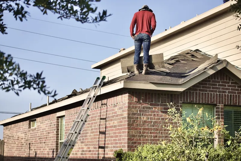 Professional roofer working on a residential roof in Proctor